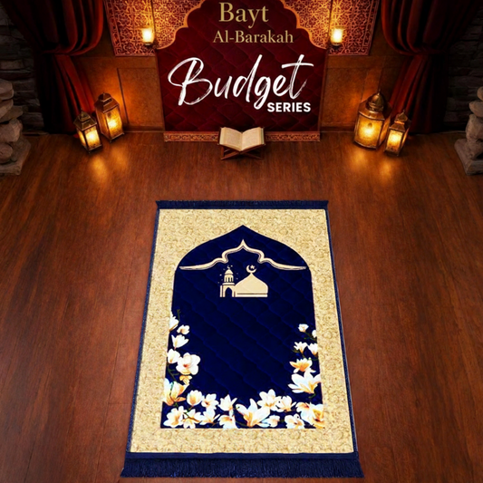 Navy blue prayer mat with floral design on a wooden floor, featuring 'Bayt Al-Barakah' branding.