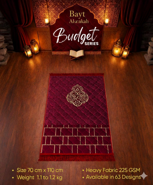 Red prayer mat with intricate design on a wooden floor, featuring 'Bayt Al-Barakah' branding.